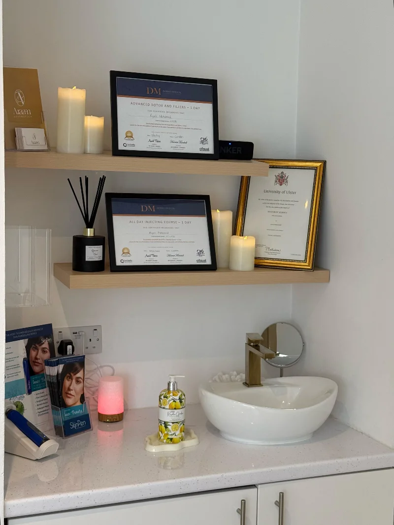Shelves with Ayah's University of Ulster and Derma Medical certificates