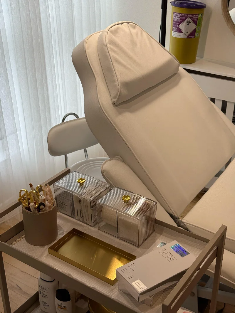 Cream treatment chair and gold-accented trolley at Araam Aesthetics
